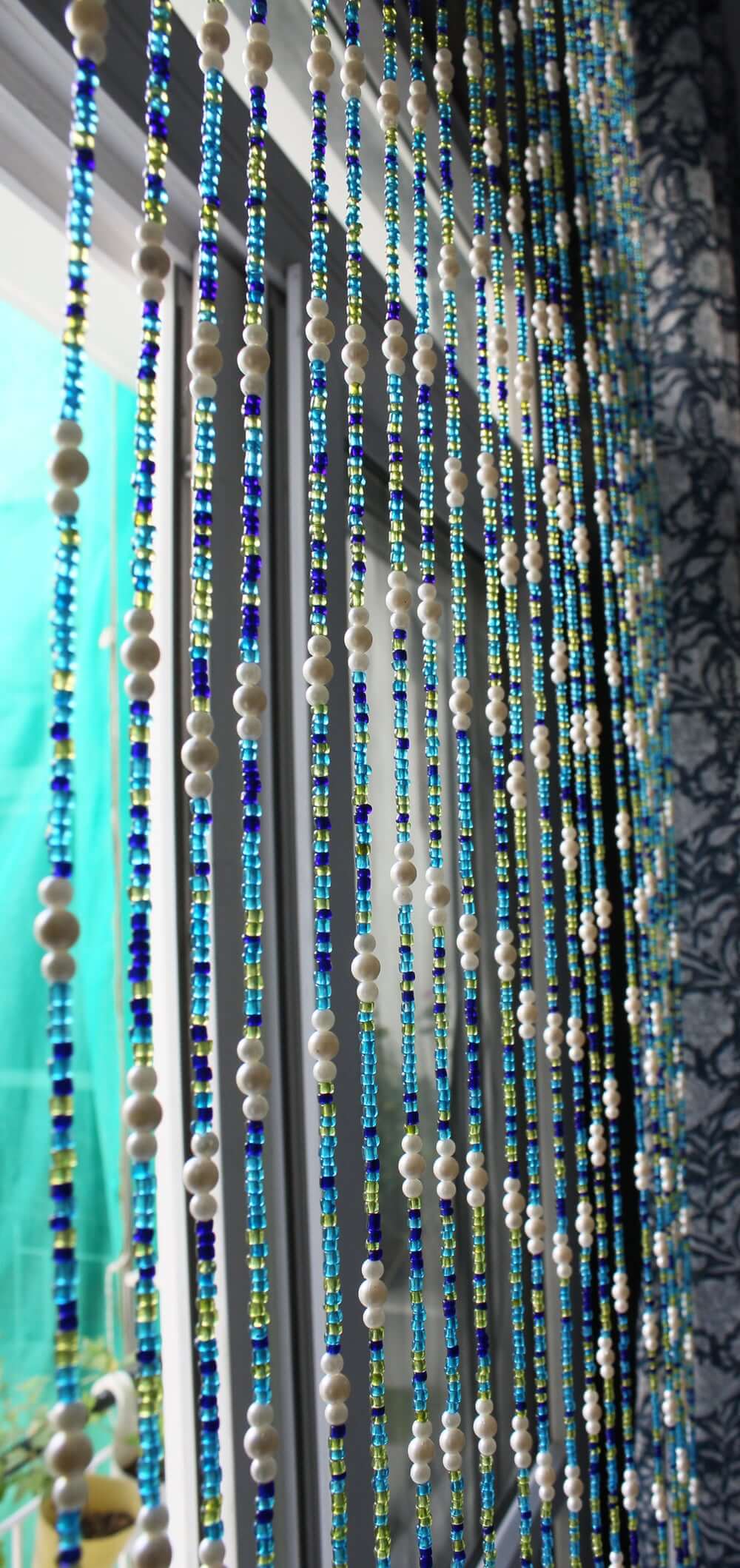 Handmade colorful glass bead strands with jingle bells—perfect for doorways or wall décor. Eco-friendly and crafted by women's artisans in India.
